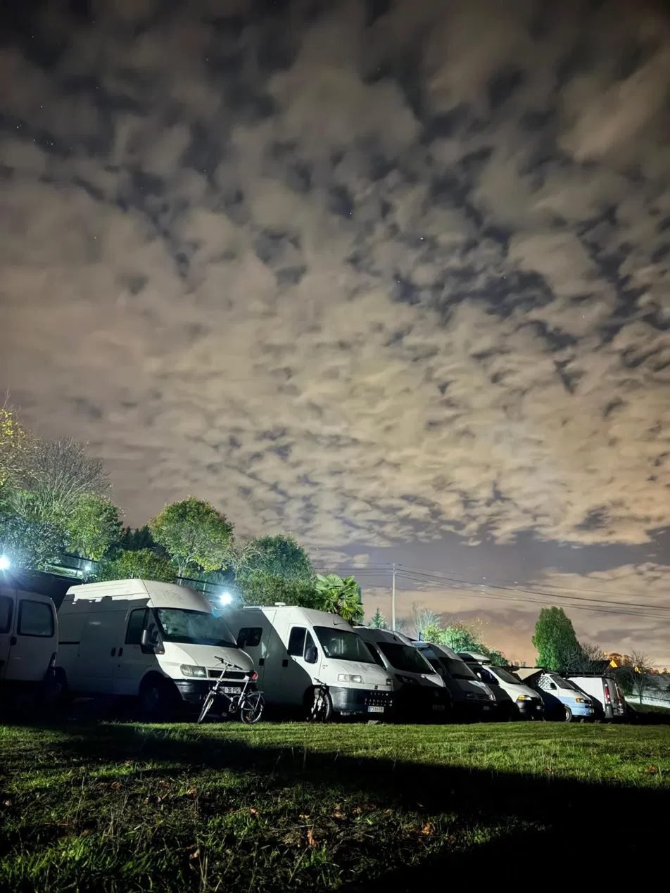 Fila de campervans à noite, sob um céu estrelado
